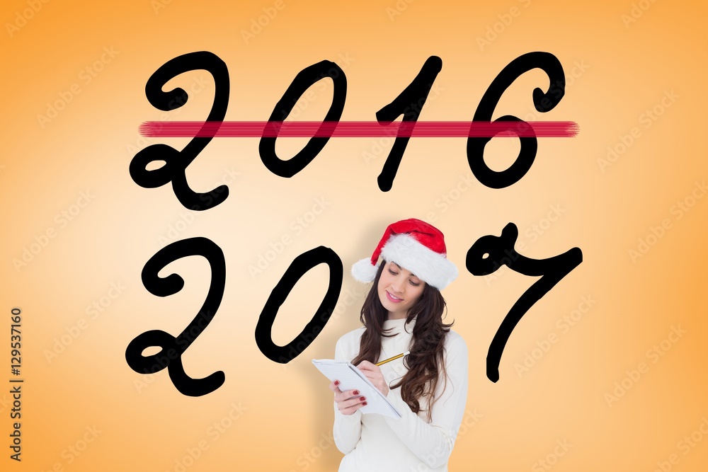 Composite image of festive brunette writing her christmas list