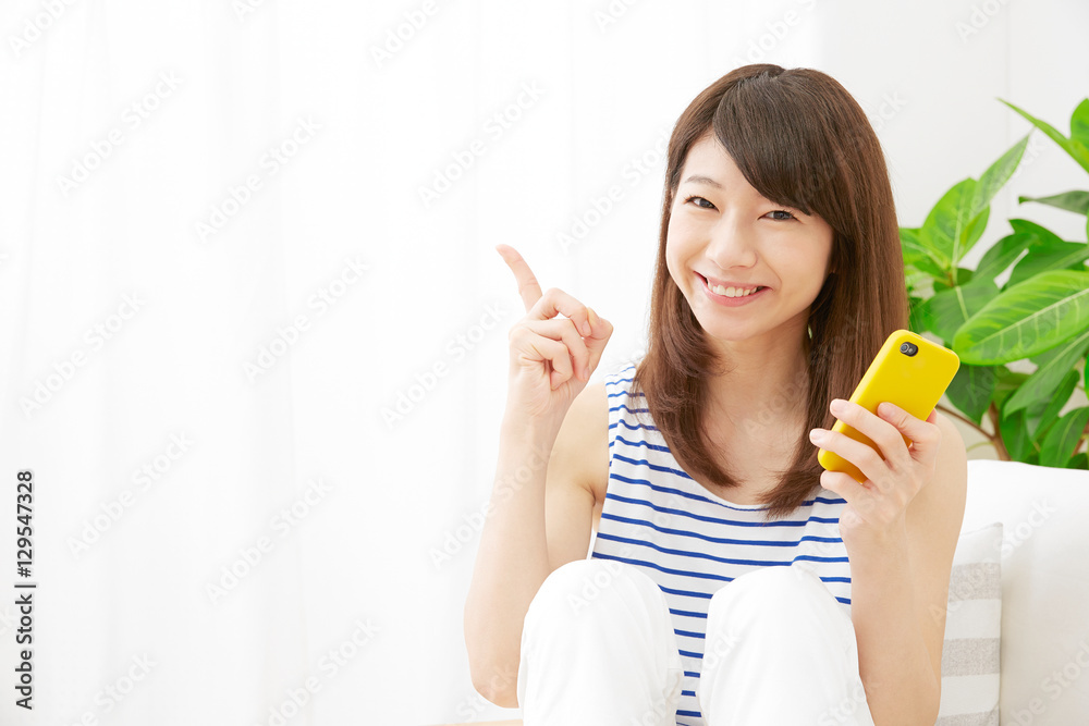 女性　スマートフォン　指差す