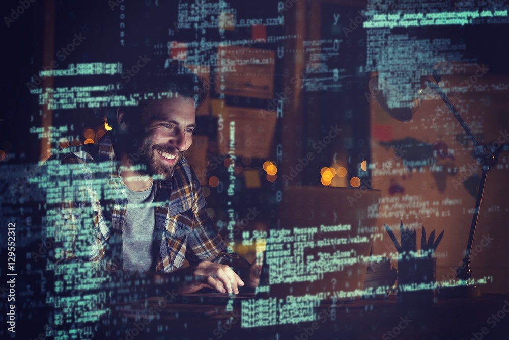 Cheerful businessman using laptop at night