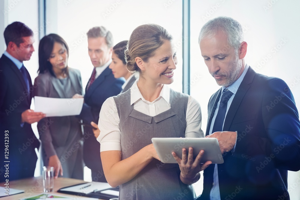 Businessman and businesswoman using digital tablet together