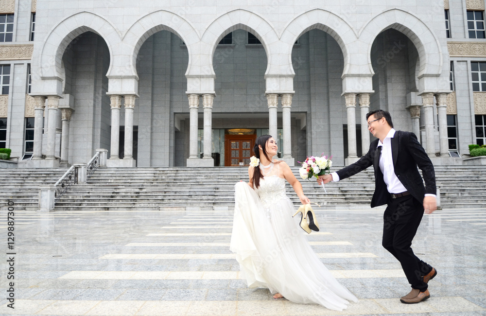 Happy bride and groom enjoying their wedding in the background of the building with beautiful archit