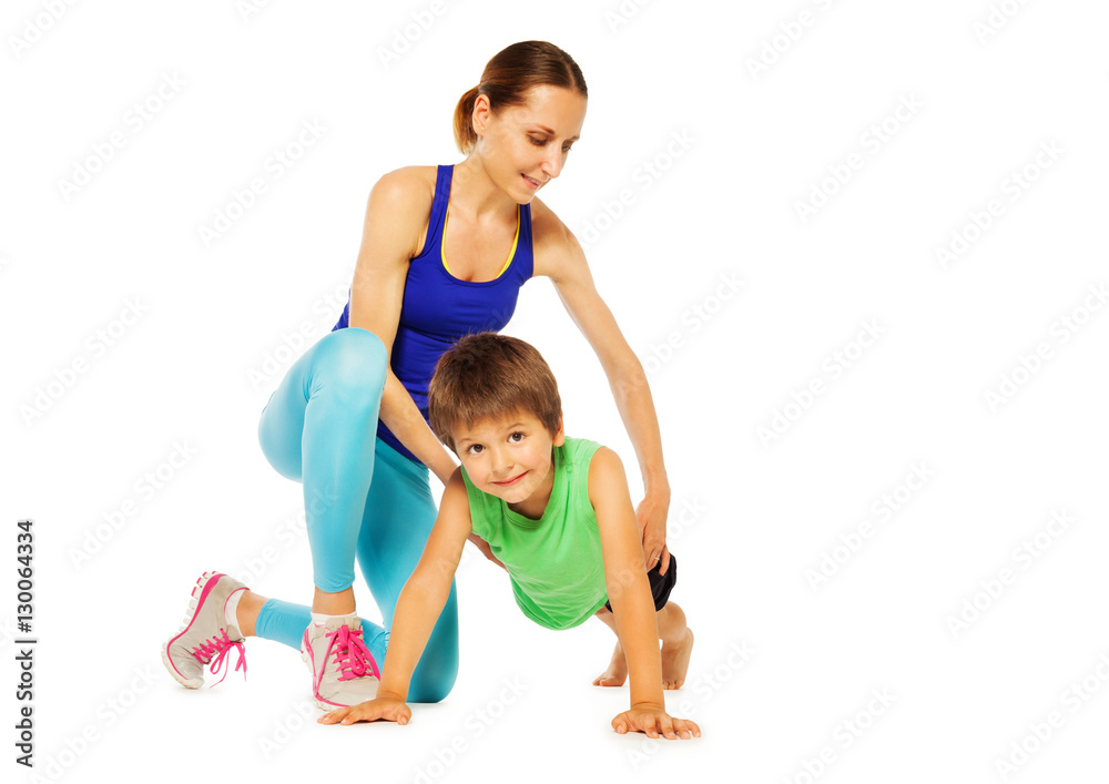 Sporty mother teaching her son doing pushing ups