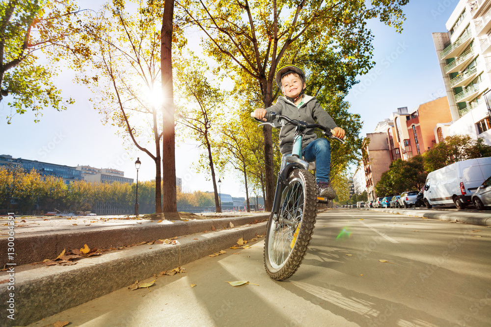 Happy boy riding his bike at city park