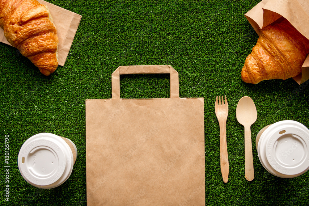 take out in paper bag on green background top view