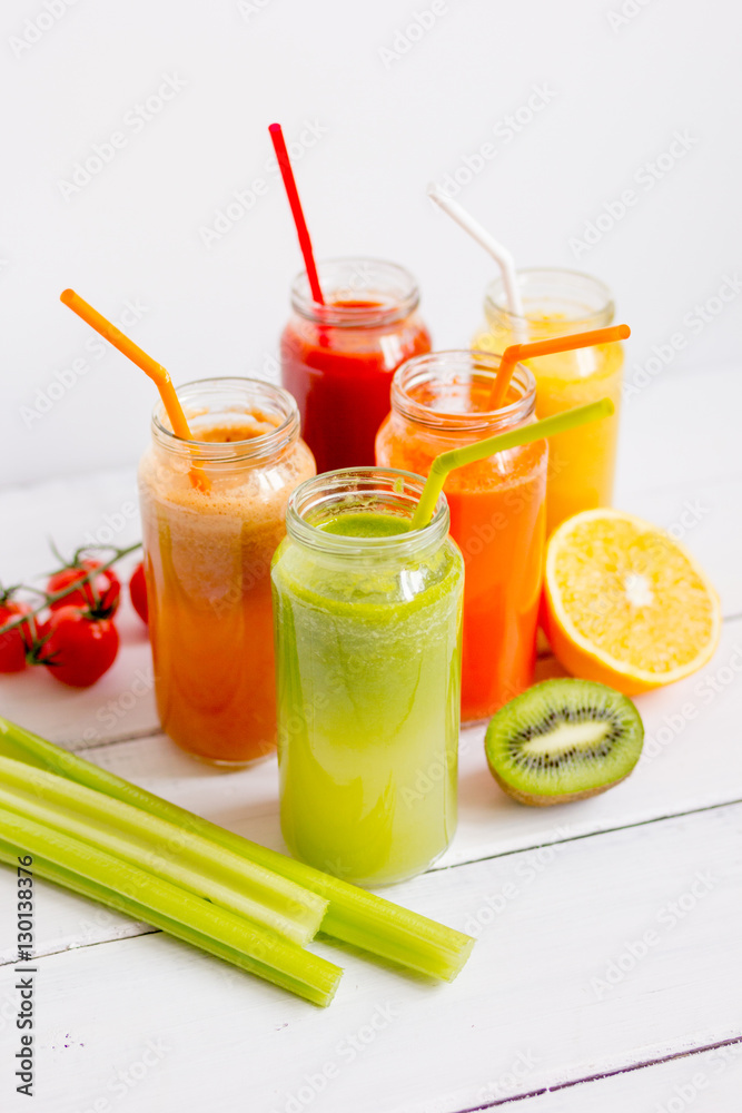 Fresh detox juices in glass bottles on white background