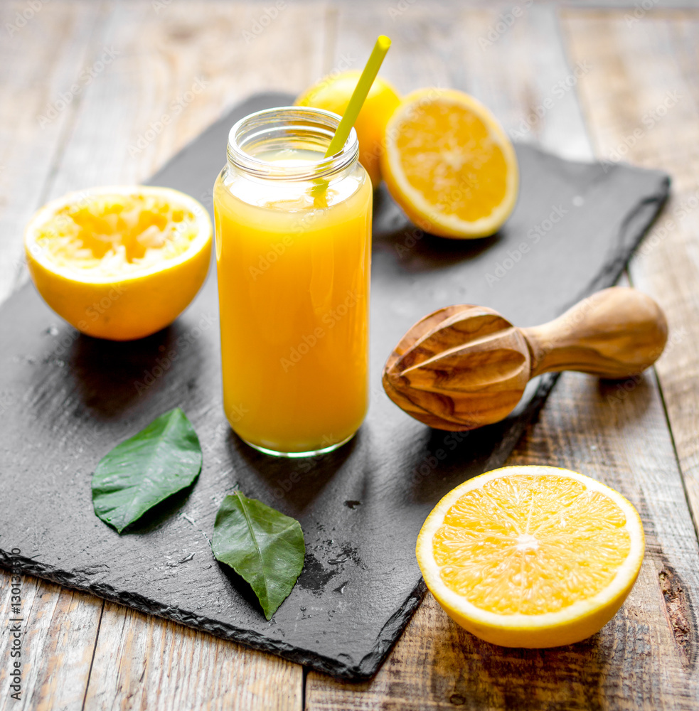 freshly squeezed orange juice in glass bottle on wooden background