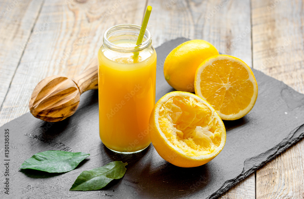 freshly squeezed orange juice in glass bottle on wooden background