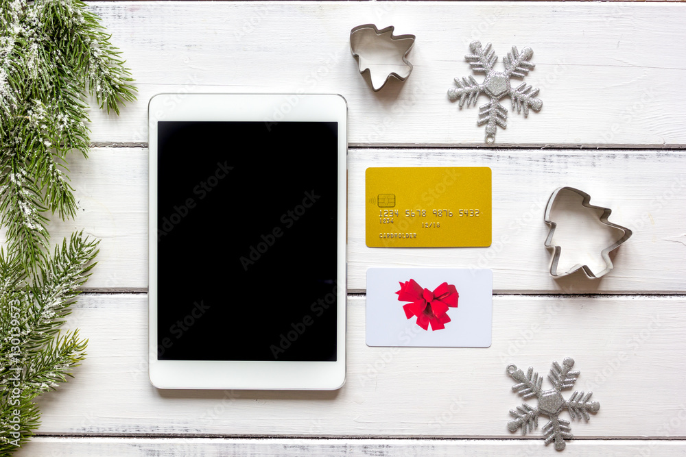 online shopping christmas with e-tablet wooden background top view