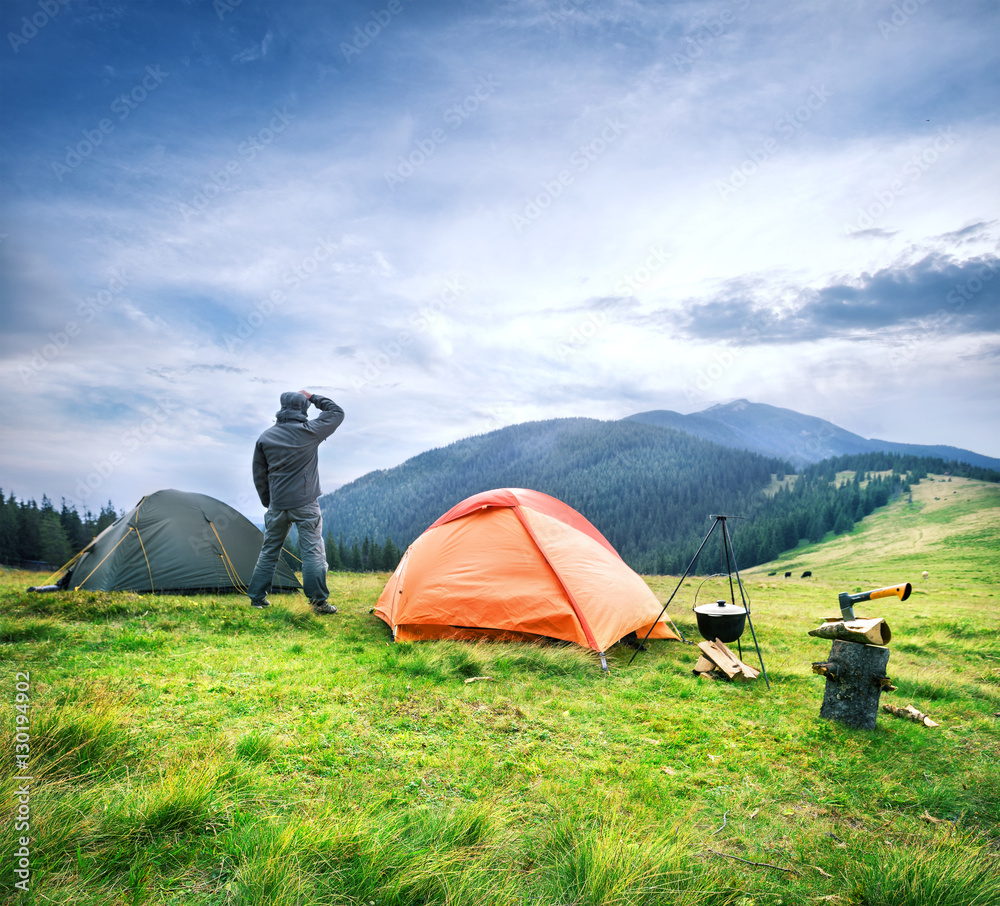 Man looks into the distance near the tent