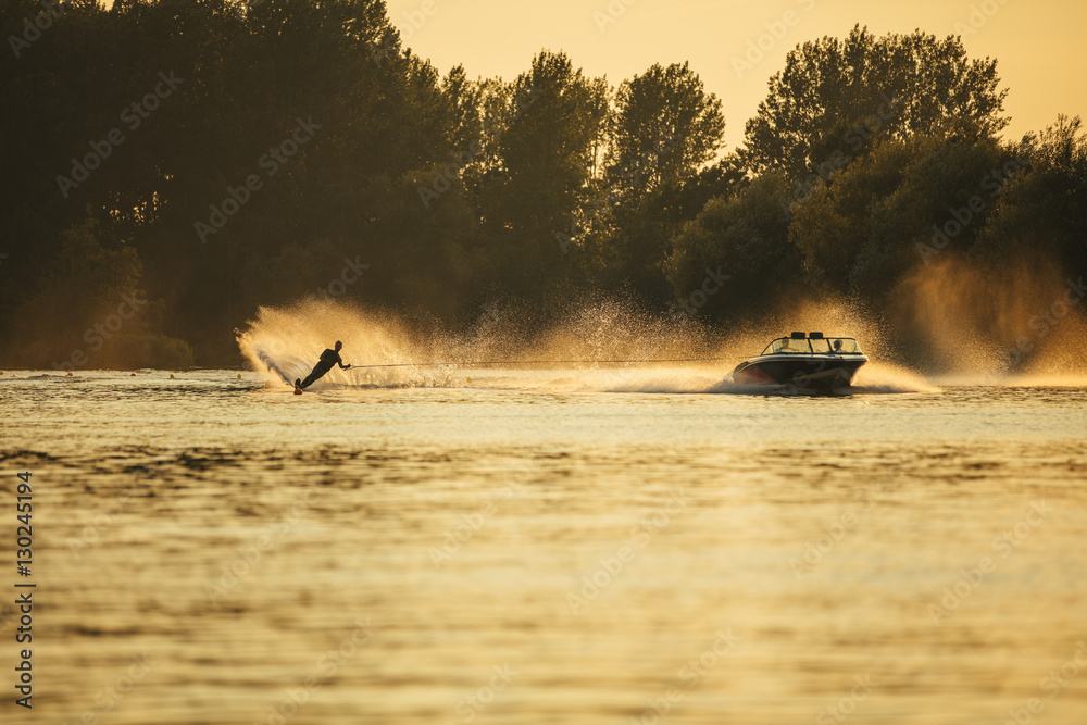 Water skiing on lake behind a boat