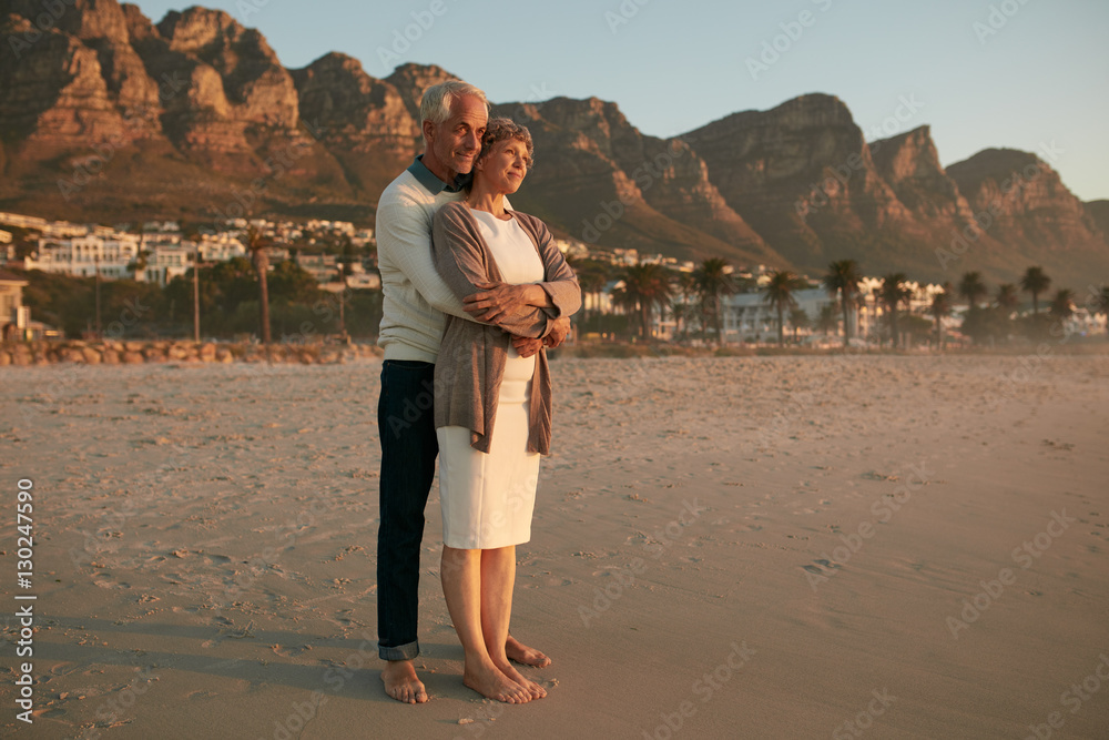 Romantic senior couple embracing on the sea shore