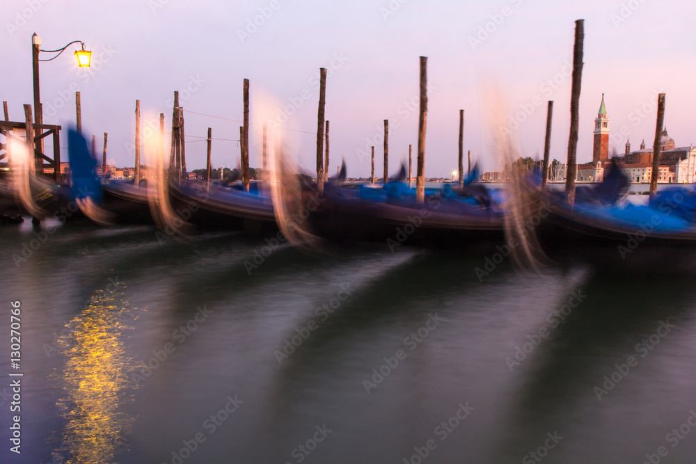 Long exposure of gondolas docked near St Marc square in Venice, Italy.