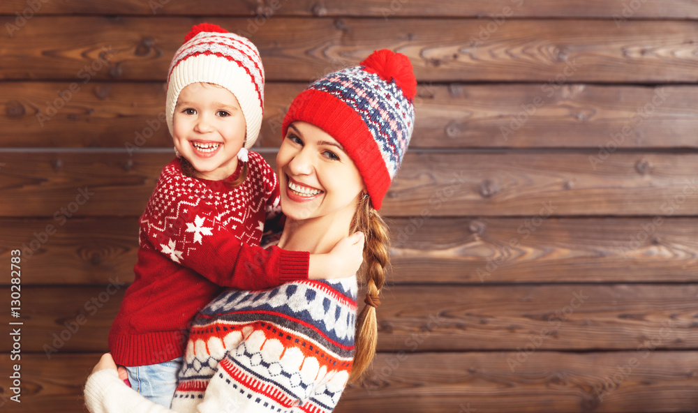 happy family mother and child girl  hugs at wooden background.