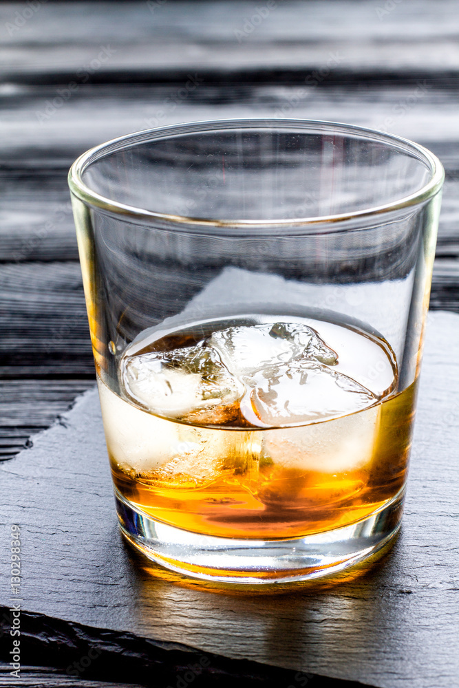 glass of whiskey on dark wooden background