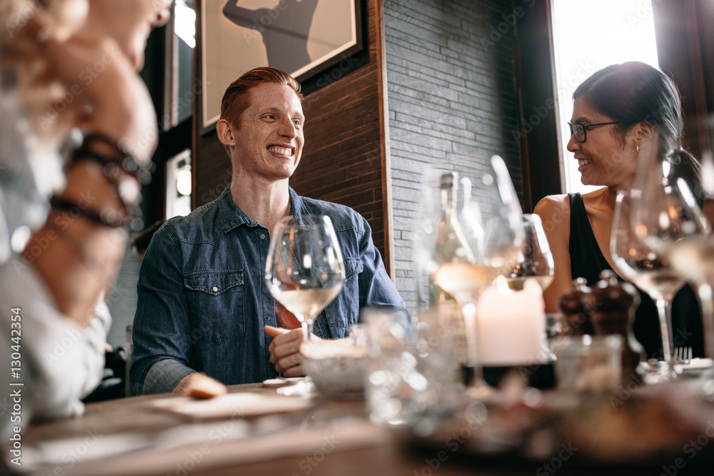 Happy young man with friends at cafe