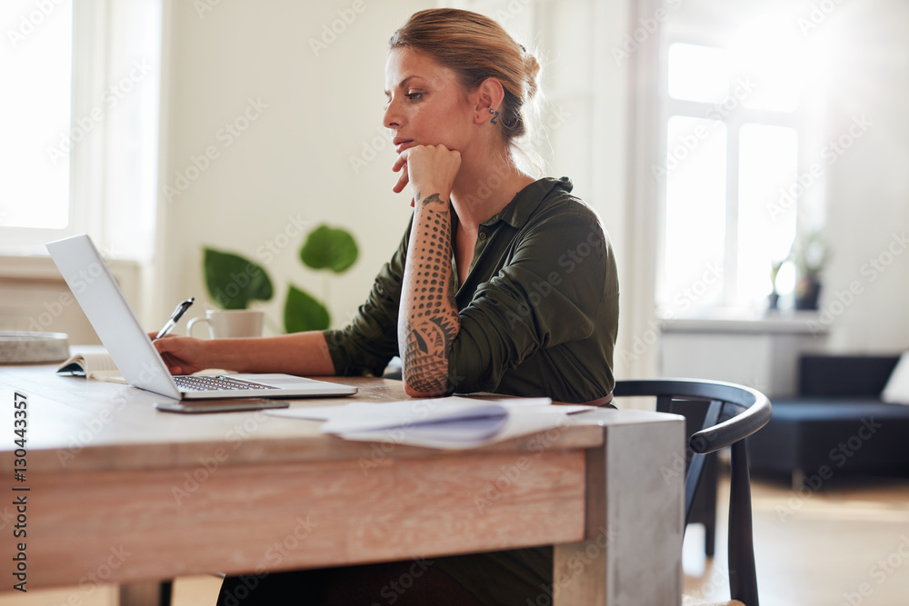 Young woman working on laptop at home office