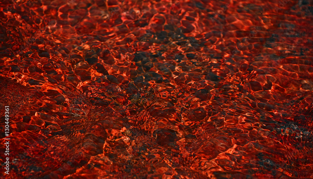 Red running water waves over stones