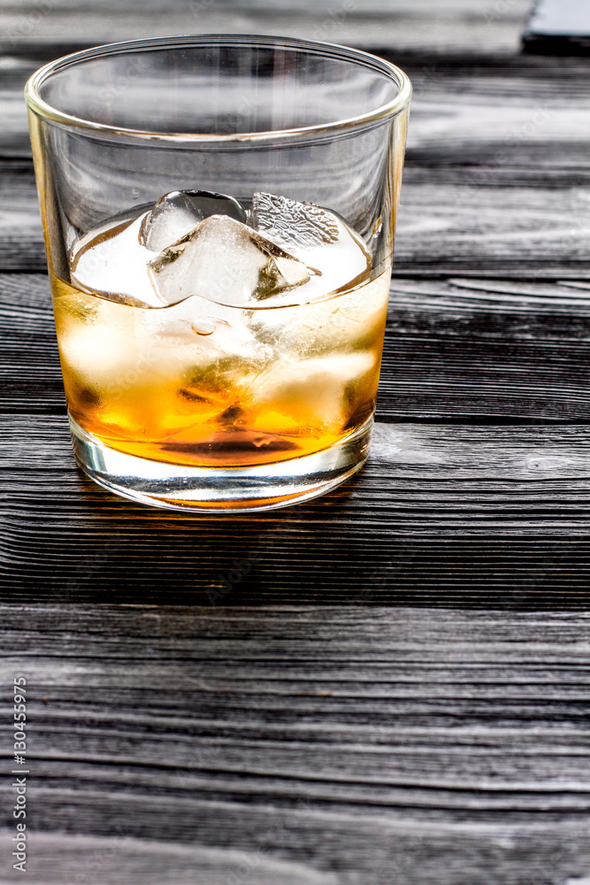 glass of whiskey on dark wooden background