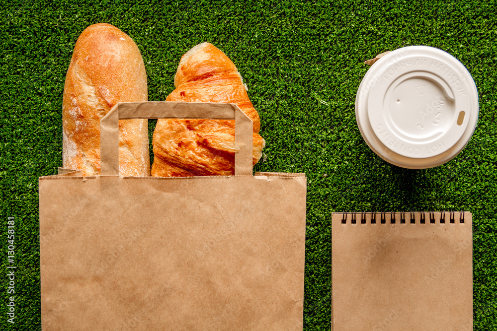 take out in paper bag on green background top view