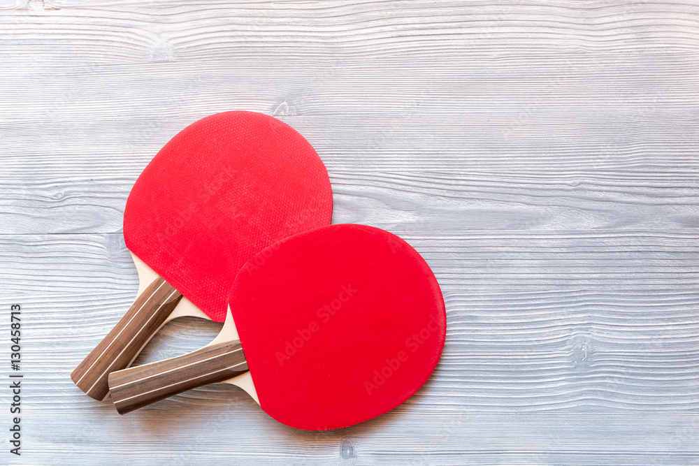 Red racket for ping pong ball wooden background top view