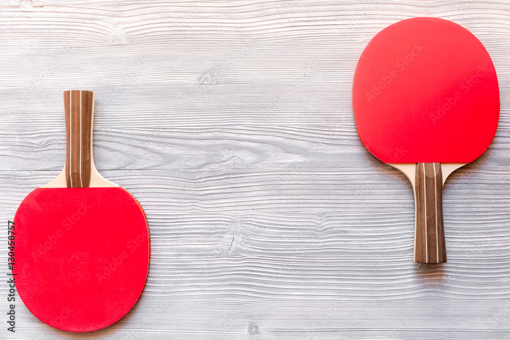 Red racket for ping pong ball wooden background top view