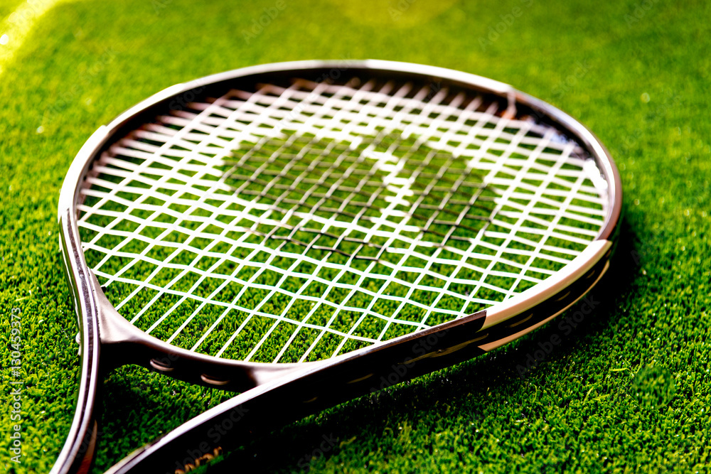 tennis racket on green background close up