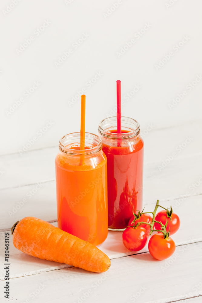 Fresh detox juices in glass bottles on white background