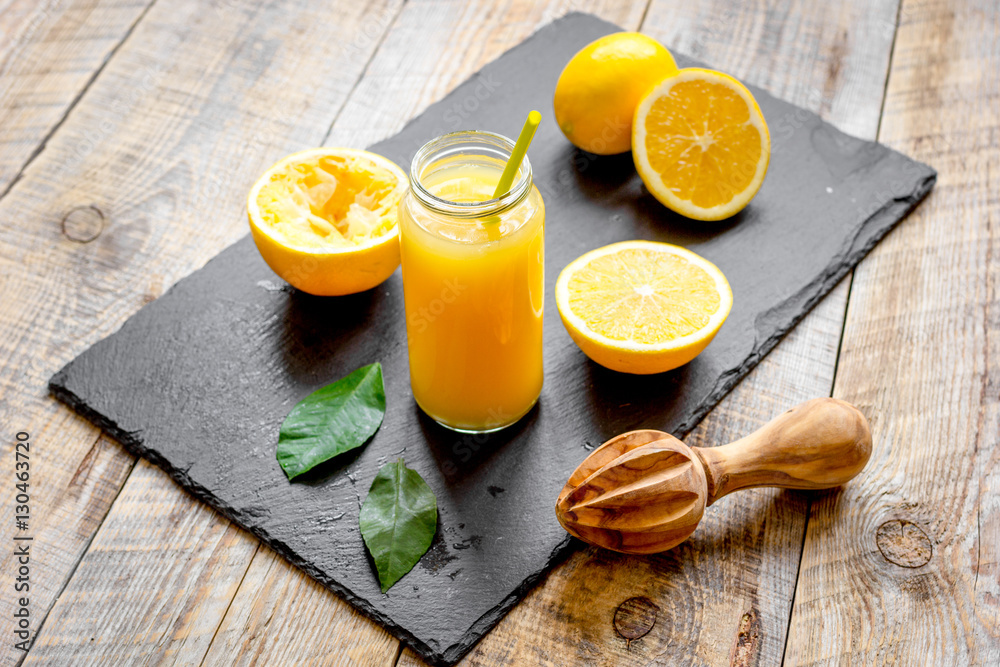 freshly squeezed orange juice in glass bottle on wooden background