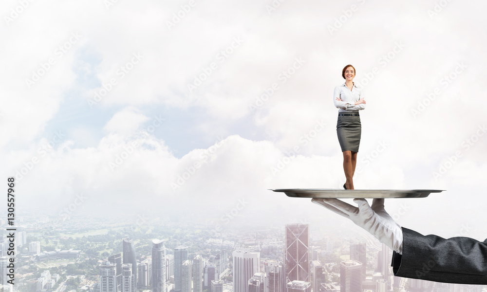 Confident elegant businesswoman presented on metal tray against cityscape background