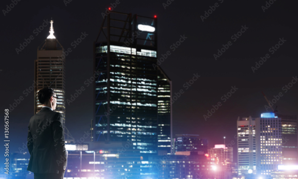 Businessman viewing night glowing city