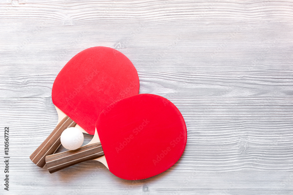 Red racket for ping pong ball wooden background top view