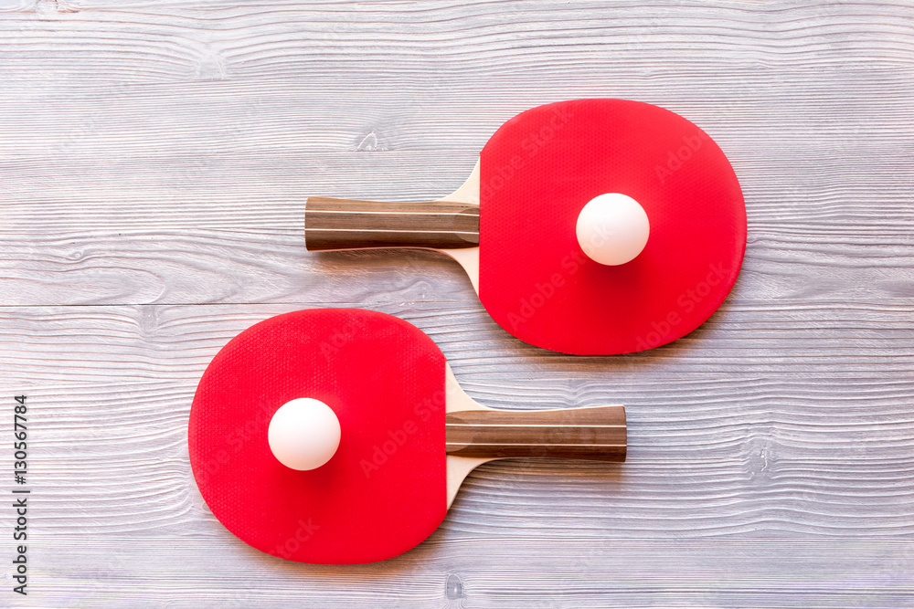 Red racket for ping pong ball wooden background top view