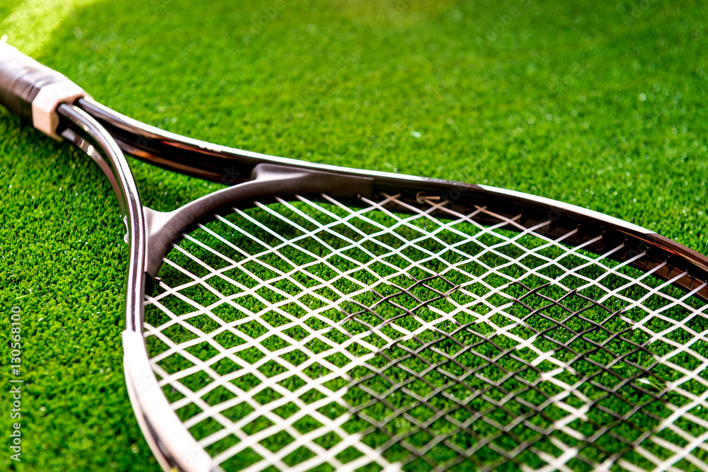 tennis racket on green background close up