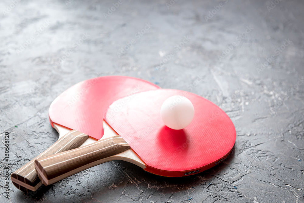 red racket for ping pong ball gray background close up