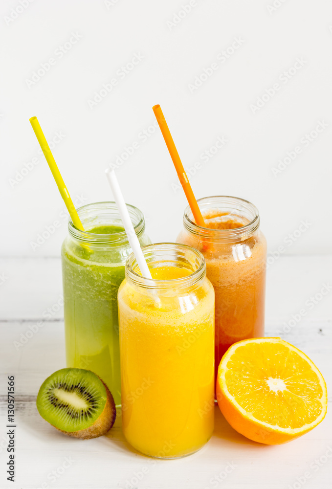 Fresh detox juices in glass bottles on white background