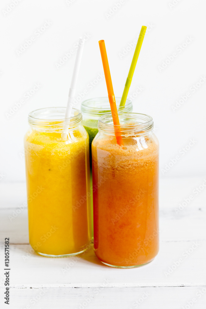 Fresh detox juices in glass bottles on white background