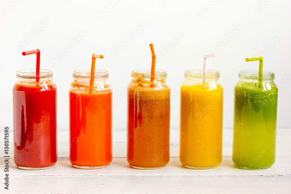 Fresh detox juices glass in row bottles on white background