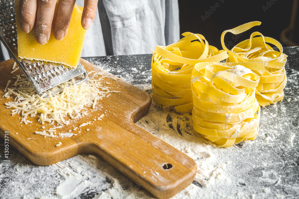 cooking pasta by chef in kitchen on dark background