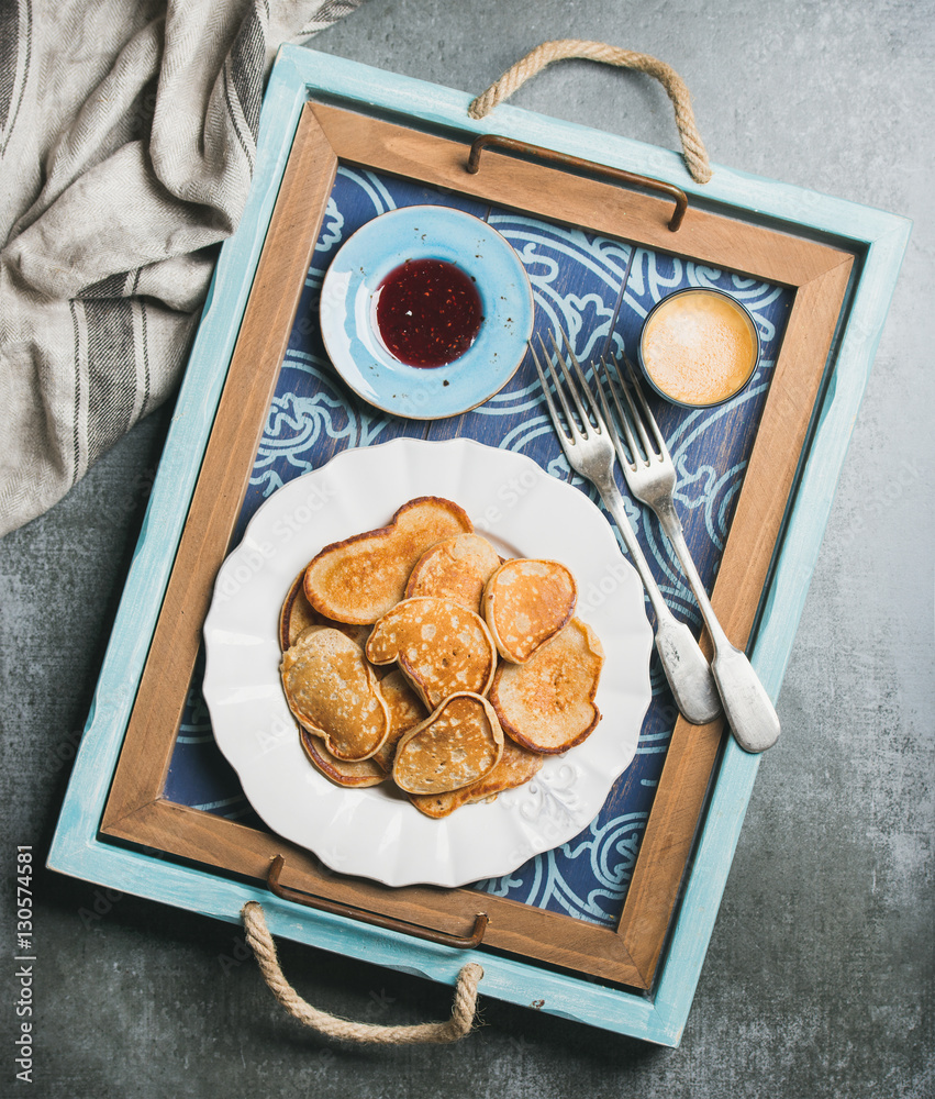 Breakfast tray with whole grain pancakes, raspberry jam and coffee espresso. Top view, shabby dark b