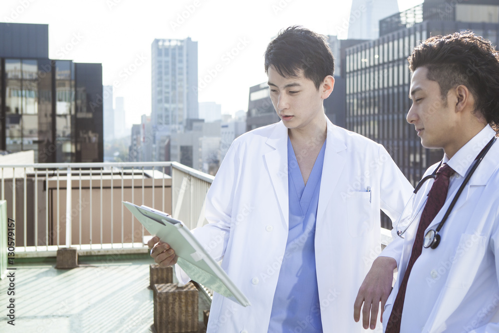 Doctors are talking while watching a medical record on the hospitals rooftop