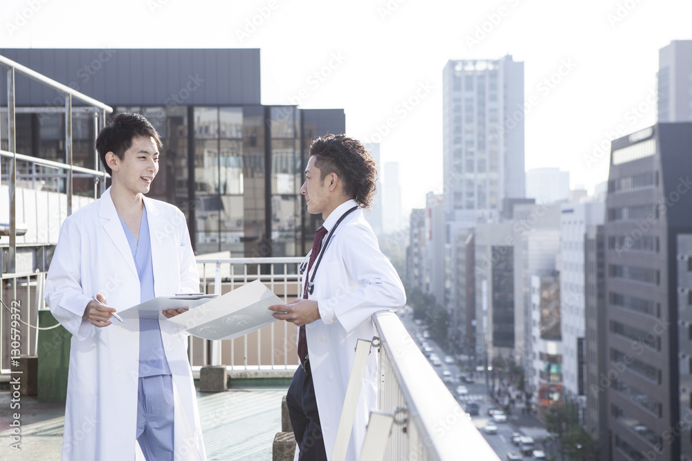 Doctors are talking while watching a medical record on the hospitals rooftop