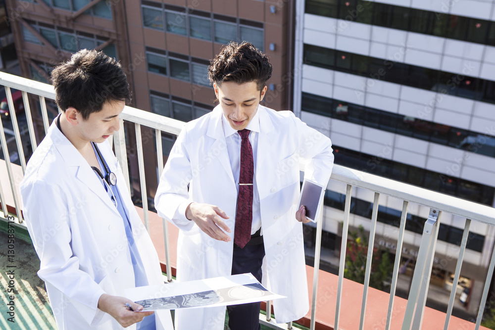 Doctors talking while watching CT images on the hospitals rooftop