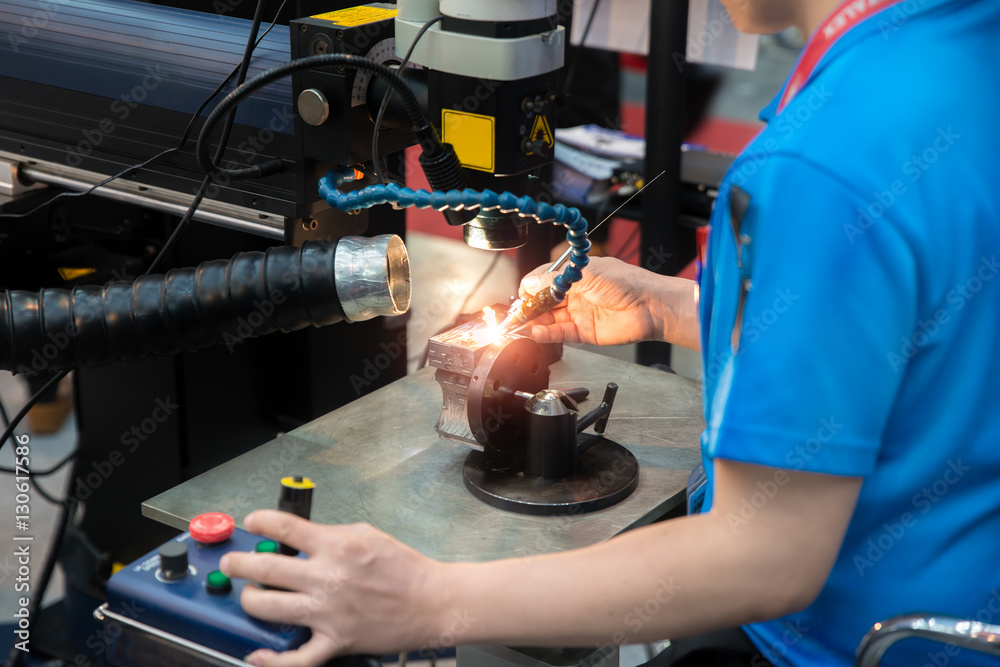 Worker welding repair mold and die part by Laser welding machine