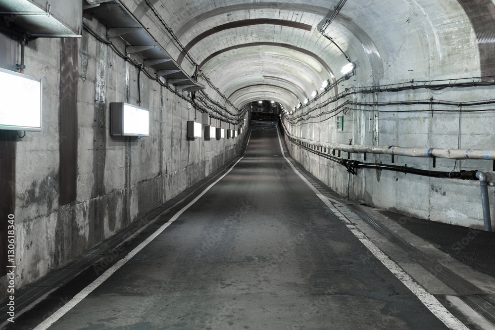 Long road tunnel with lighting. Empty car in tunnel.