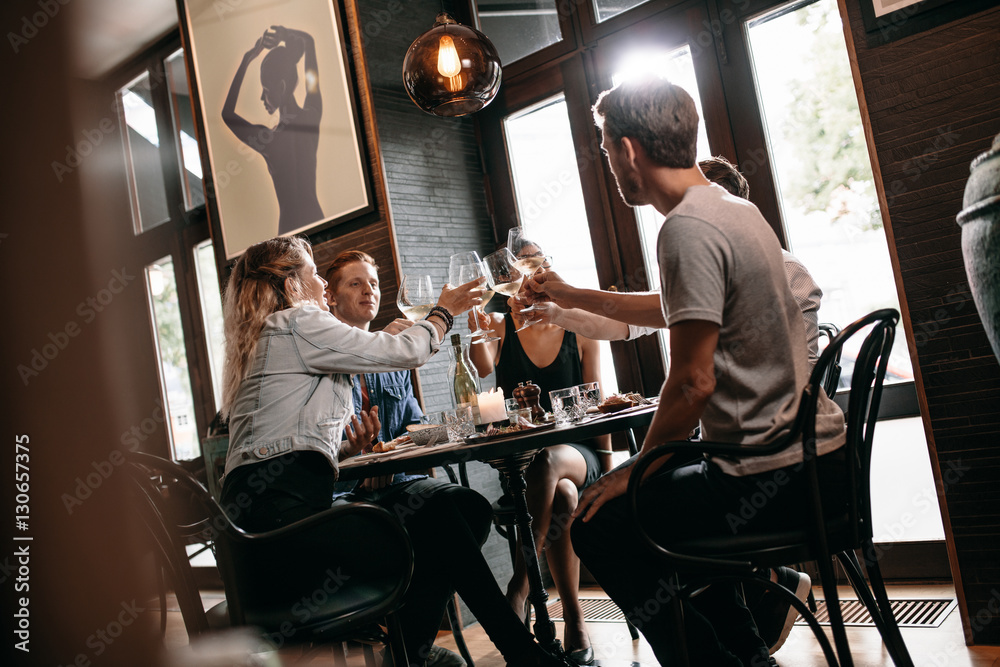 Group of friends toasting at restaurant