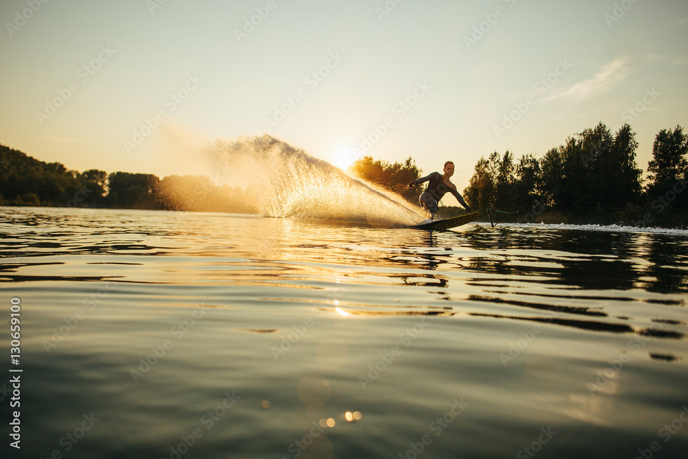 Wakeboarder moving fast in splashes of water