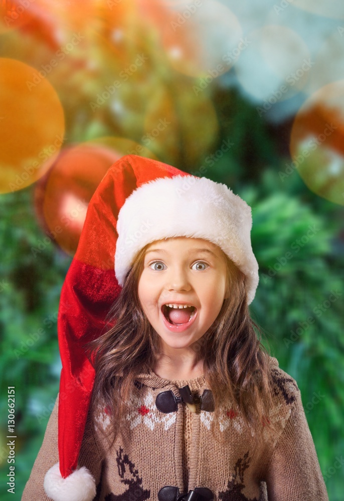 Happy child girl in a christmas hat.