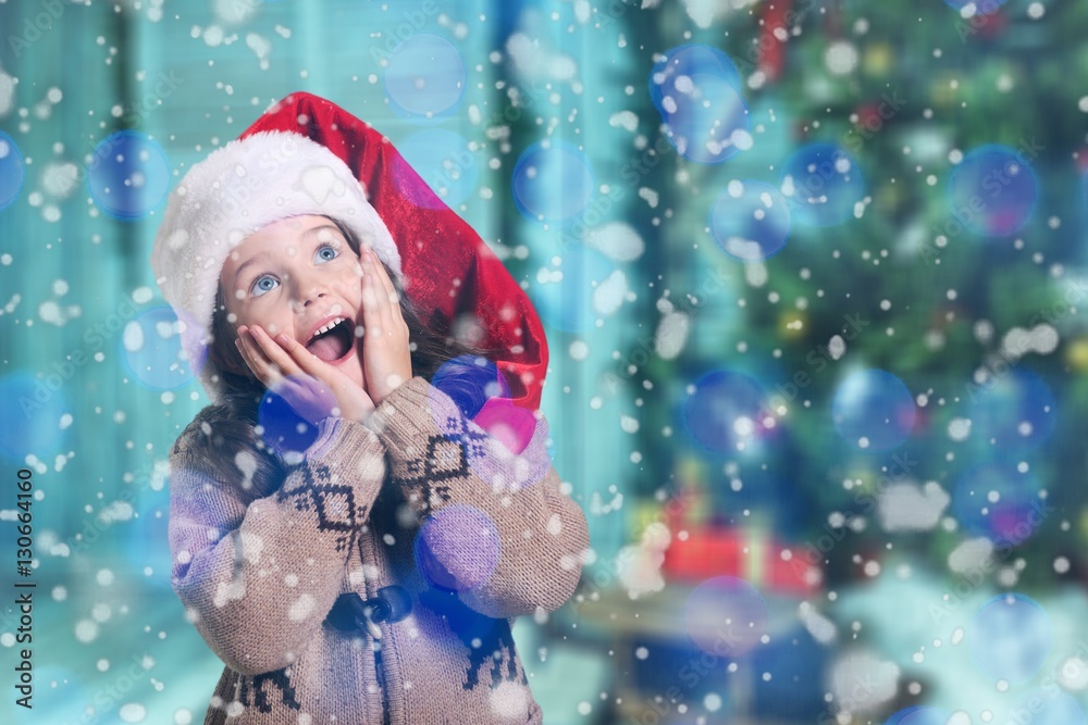 Happy child girl in a christmas hat.