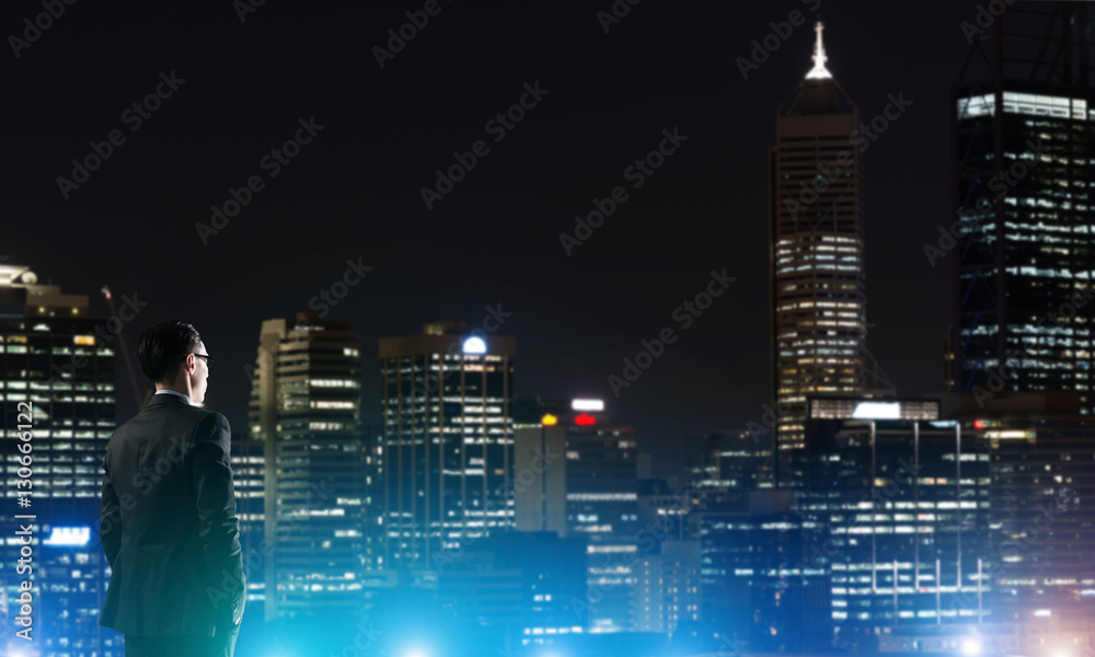 Businessman viewing night glowing city