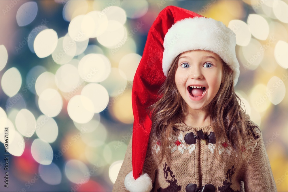 Happy child girl in a christmas hat.